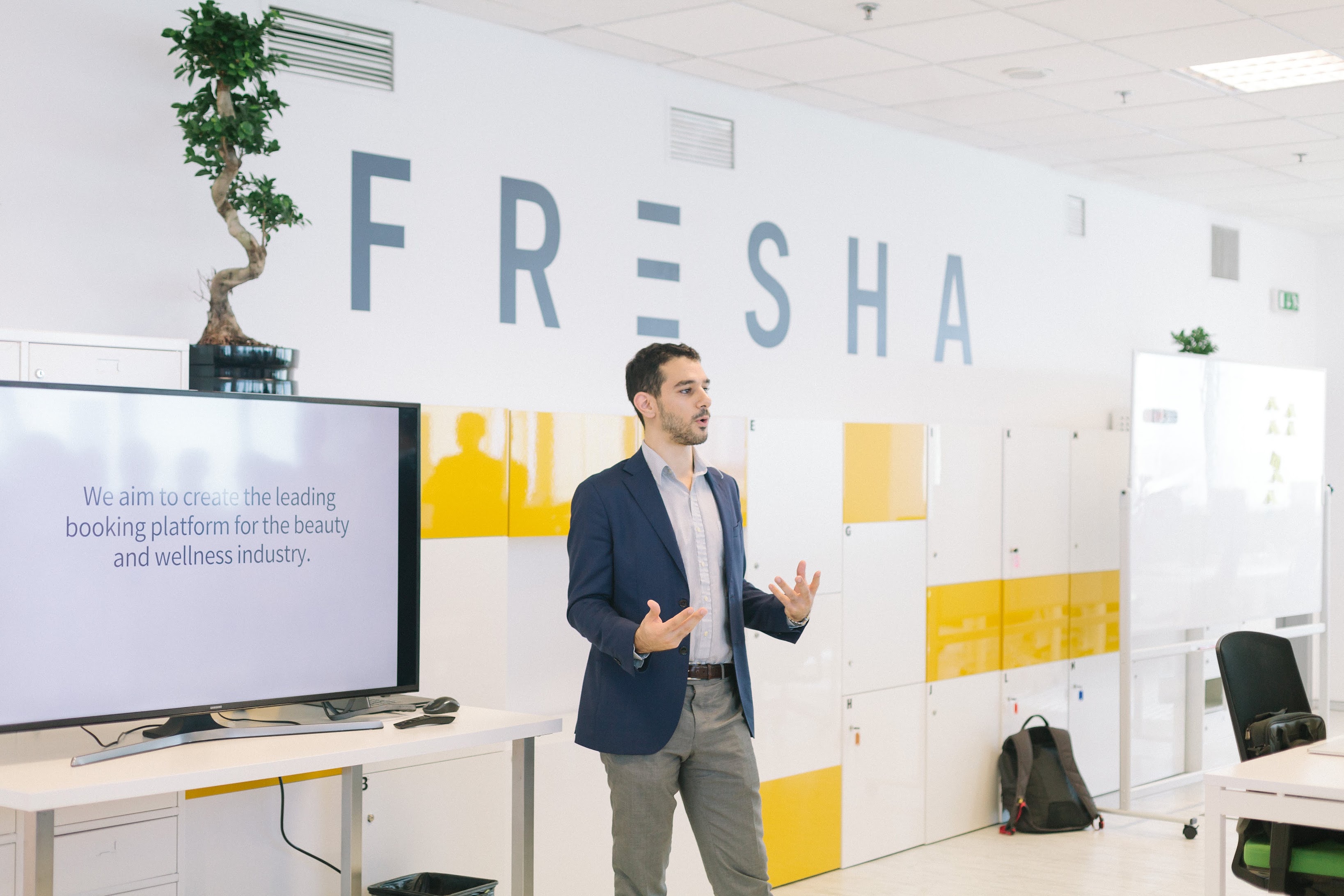 Mark Khoury presenting to the team in front of the Fresha logo